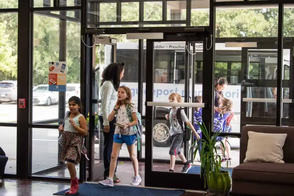Children and families arriving at Guidepost Montessori school entrance in the morning