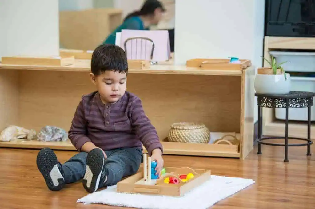 parenting advice for preschoolers child working independently with Montessori materials on floor mat