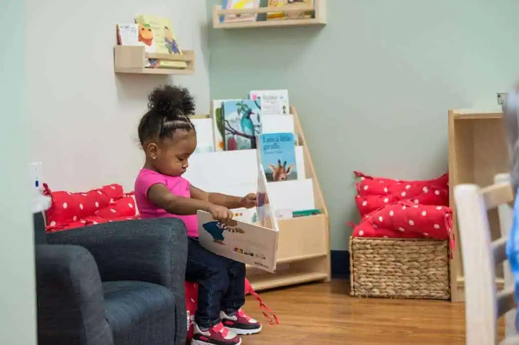 parenting advice for preschoolers child reading book in Montessori classroom reading nook