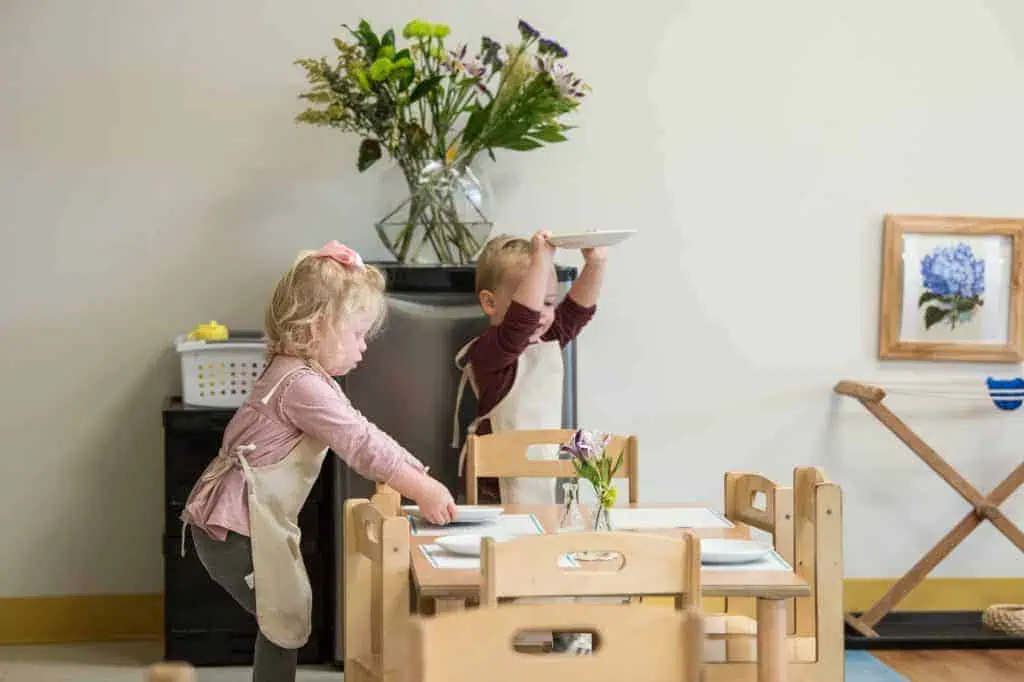 Children setting a dining table together as part of practical life work in the Guidepost Montessori experience