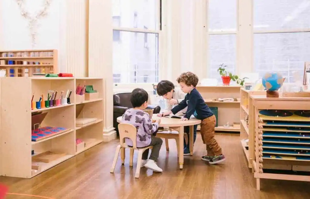 Children collaborating in a modern Montessori classroom at Guidepost Montessori, illustrating how education can cultivate peace and cooperation in the next generation.