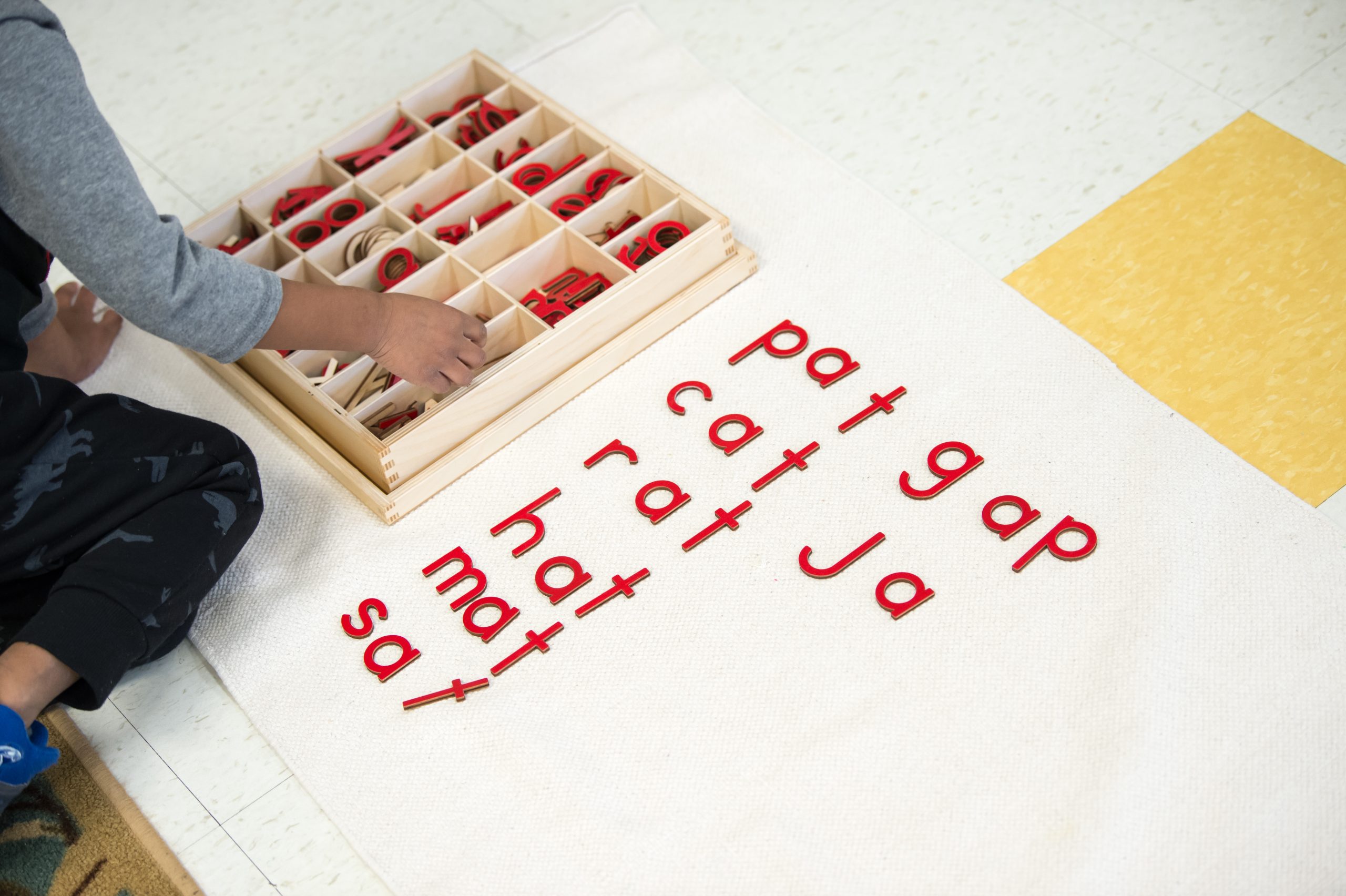 Child using Montessori moveable alphabet for AI learning vs hands-on learning