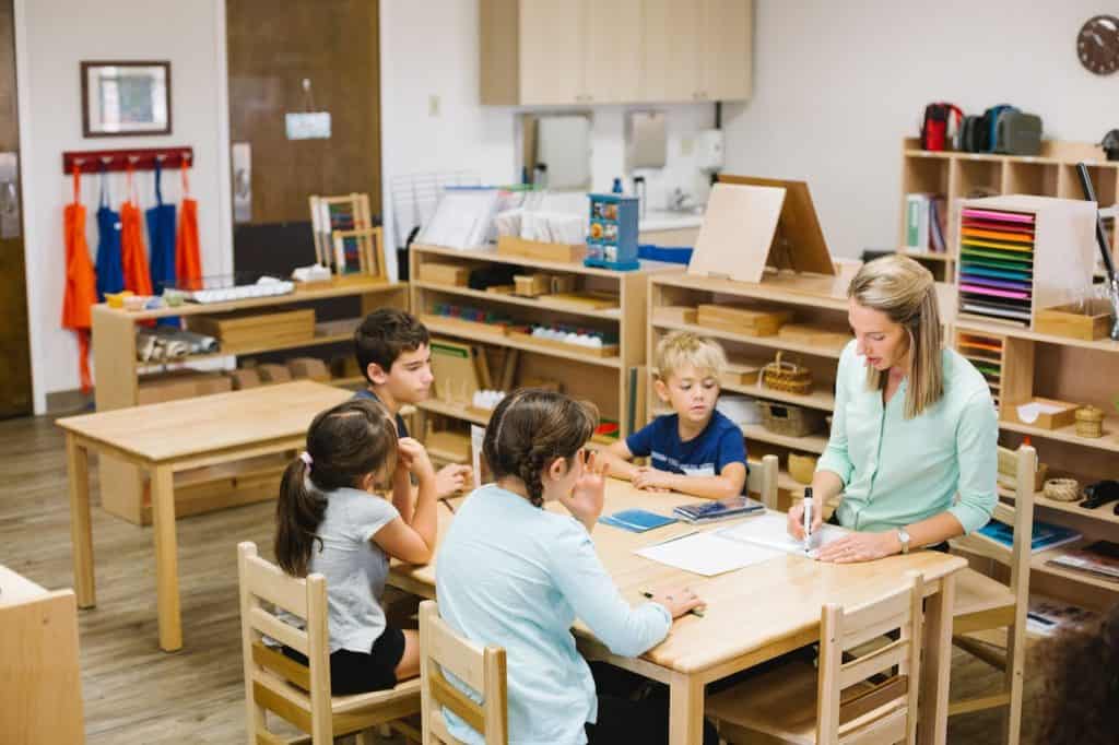 Teacher engaging with children in a Montessori classroom setting.